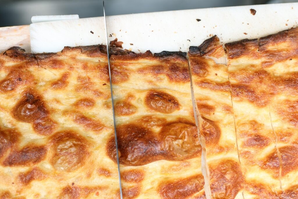 Close-up of crispy focaccia pizza sliced fresh in Rome