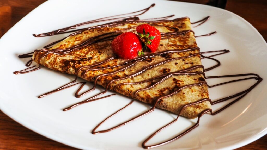 Dessert pancake topped with strawberries and chocolate sauce in Rotterdam