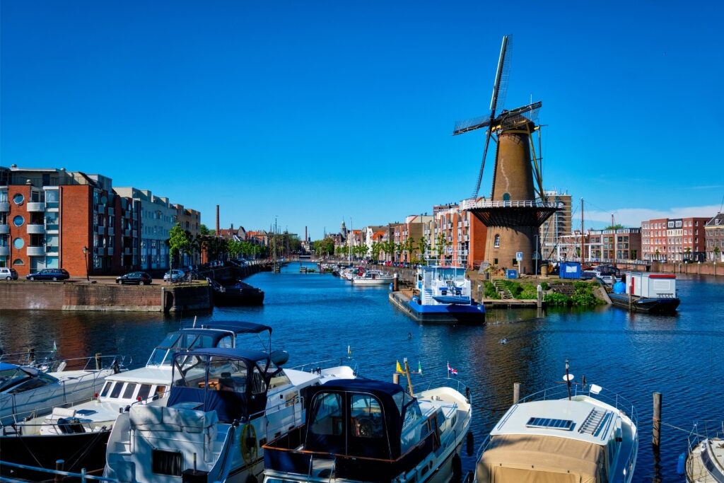 View of Delfshaven harbour with the historic grain mill De Destilleerketel
