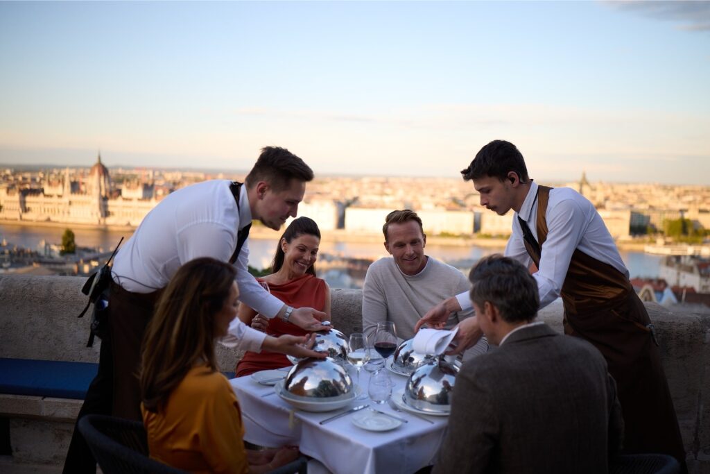 Tourist dining al fresco with a scenic view of Budapest in the background