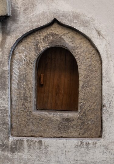 Historic Florentine wine window, or buchetta del vino, on a stone wall