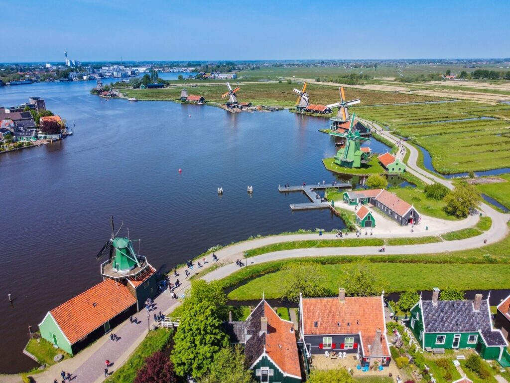 Aerial landscape of Zaanse Schans with fields, houses, windmills, and waterways