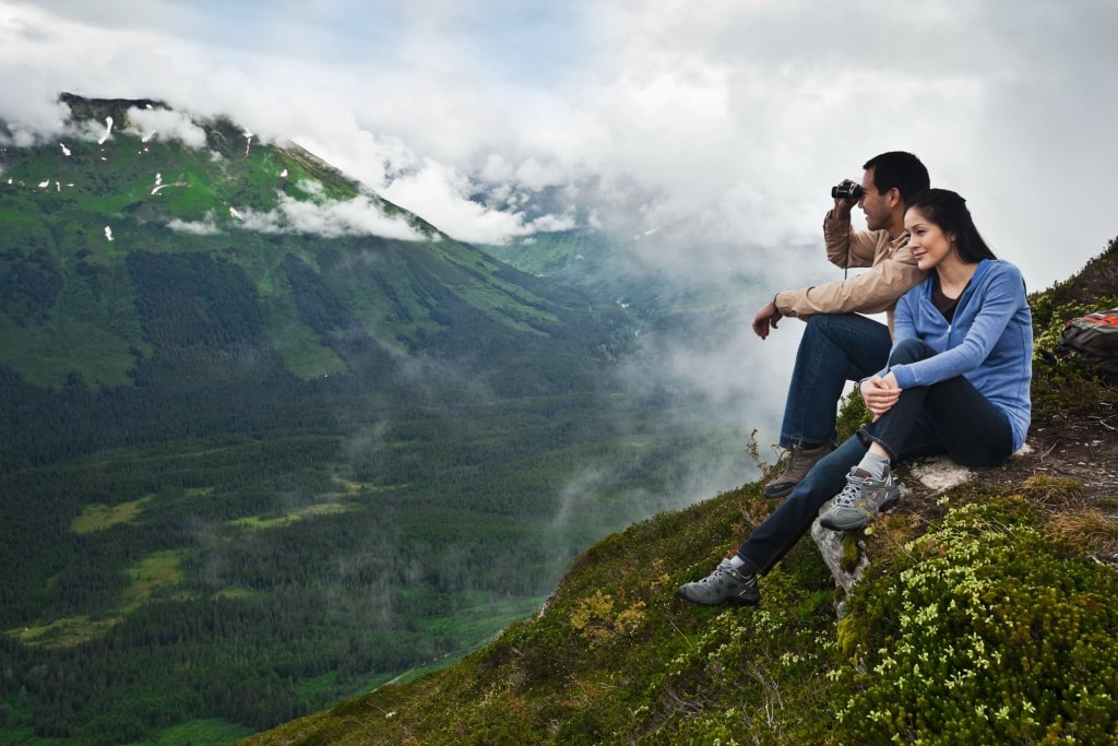 A couple sitting on mountain at Alaska.