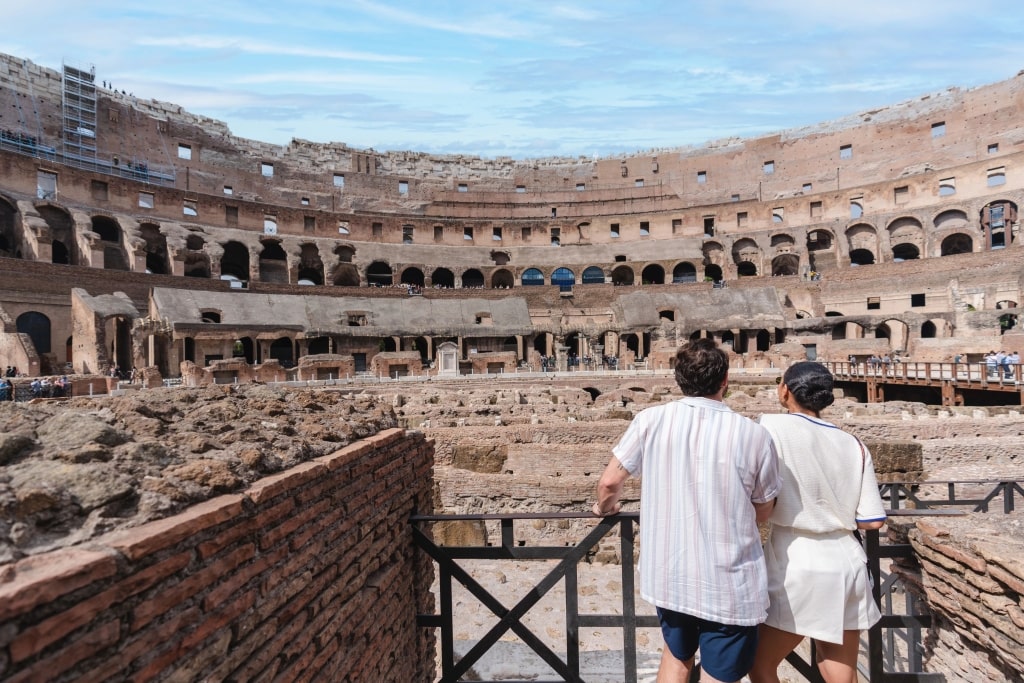 Curious couple admiring iconic Rome Colosseum ancient stone amphitheater ruins