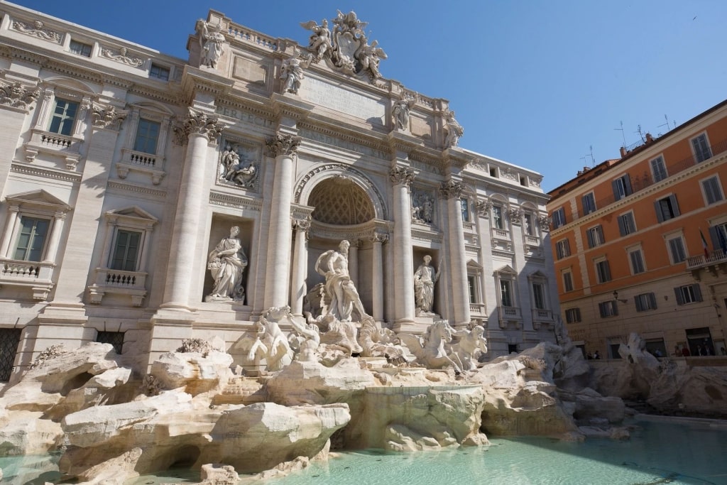 Intricate Trevi Fountain Baroque marble sculptures framing the cascading turquoise pool water