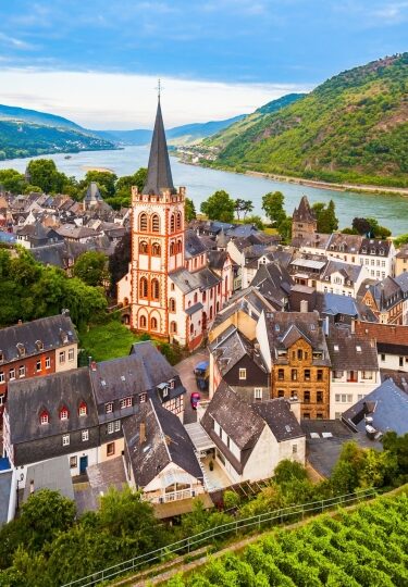 Historic half-timbered architecture and lush vineyard terraces gracing rich river valleys inspiring romantic Rhine River cruises.