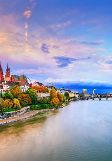 Basel, Switzerland on the Rhine River at dusk in autumn.