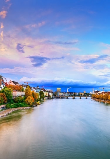 Basel Minster twin spires and Old Town architecture framing the scenic Rhine River.