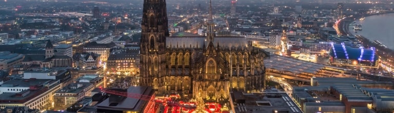 Cologne, Germany - Dec 14, 2025 : Aerial view of the Cologne Cathedral Christmas Market (Weihnachtsmarkt am Kölner Dom) on Roncalliplatz at sunset - Holiday celebrations in Germany