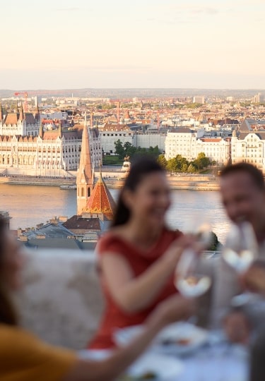 Diners enjoy a rooftop view of the majestic Hungarian Parliament Building across the river.