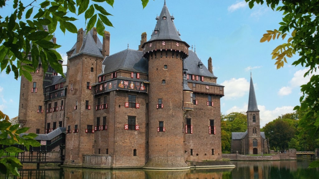 De Haar Castle's grand brick towers and turrets surrounded by a peaceful moat.