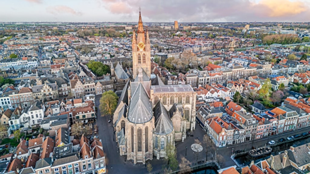 A beautiful aerial view of the historic Oude Kerk surrounded by Delft’s traditional rooftops. 