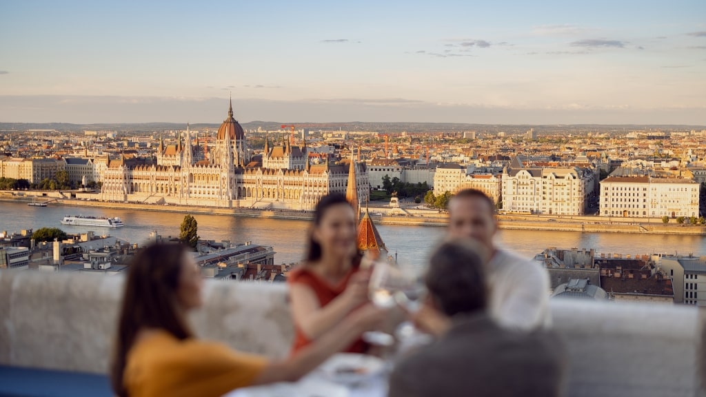 Diners enjoy a rooftop view of the majestic Hungarian Parliament Building across the river.