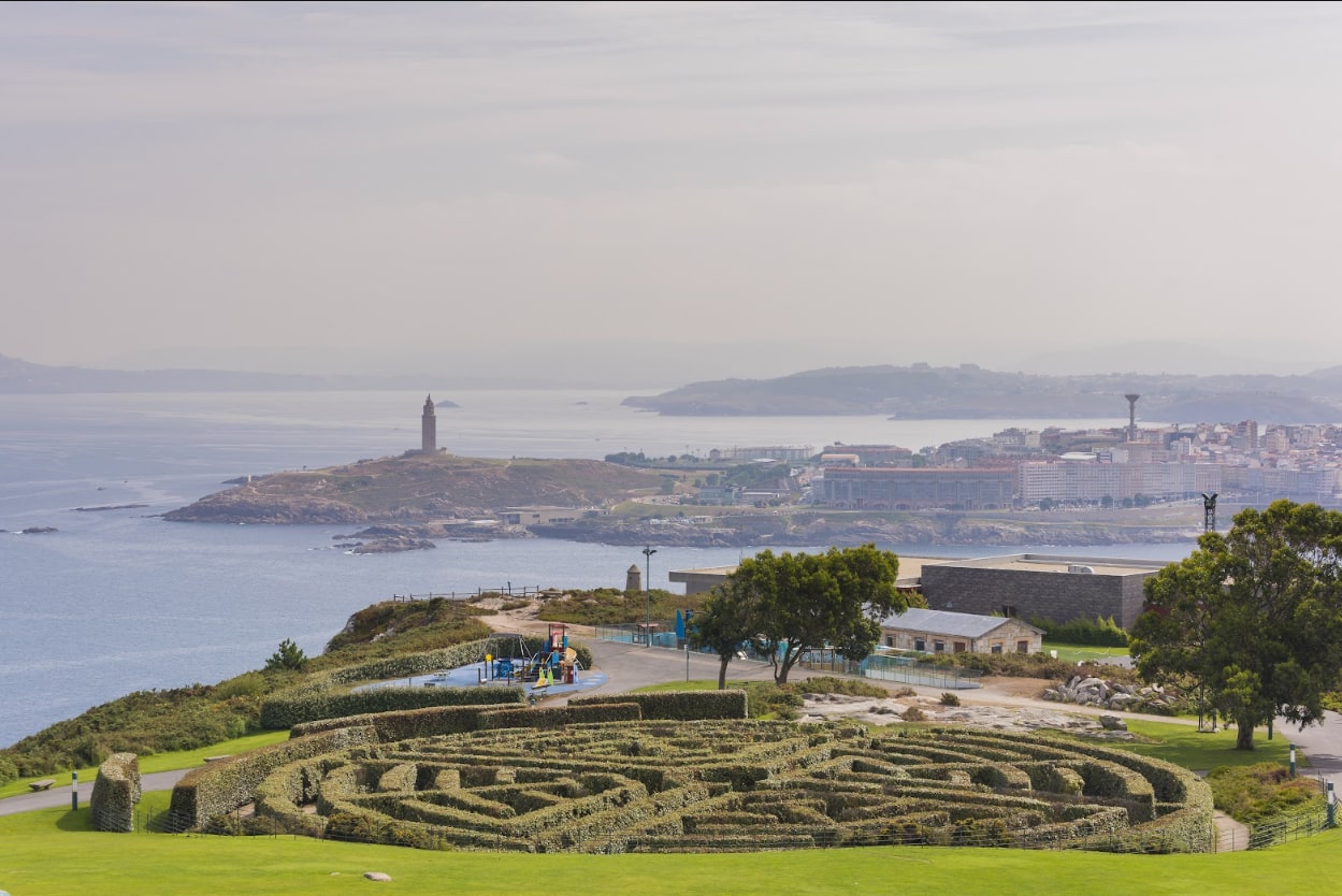 Within Monte de San Pedro, a meticulously manicured hedge maze offers a playful vantage point over the rugged Galician shore and the iconic Roman lighthouse.