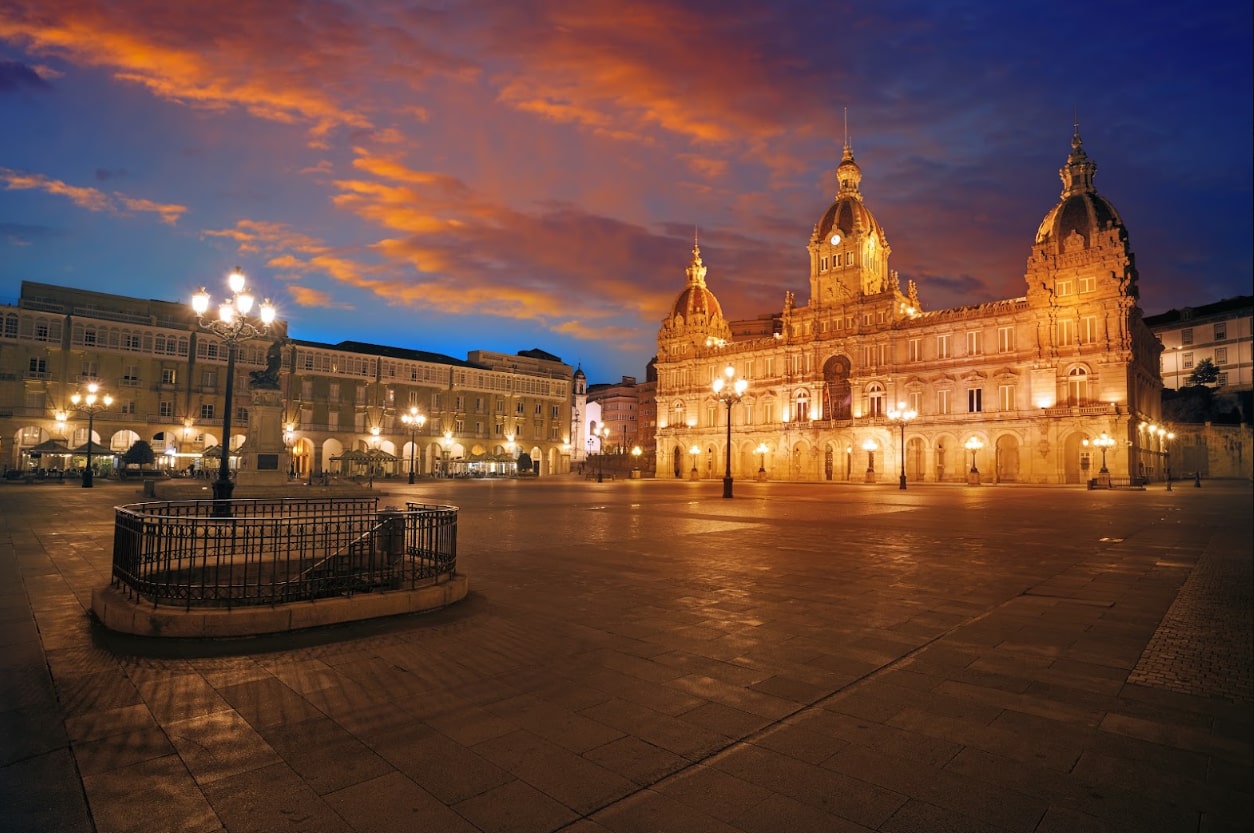 The grand City Hall in María Pita Square glows under a dramatic twilight sky in La Coruña.