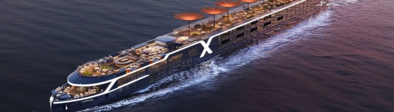 Aerial view of the illuminated Celebrity Compass river ship at dusk.