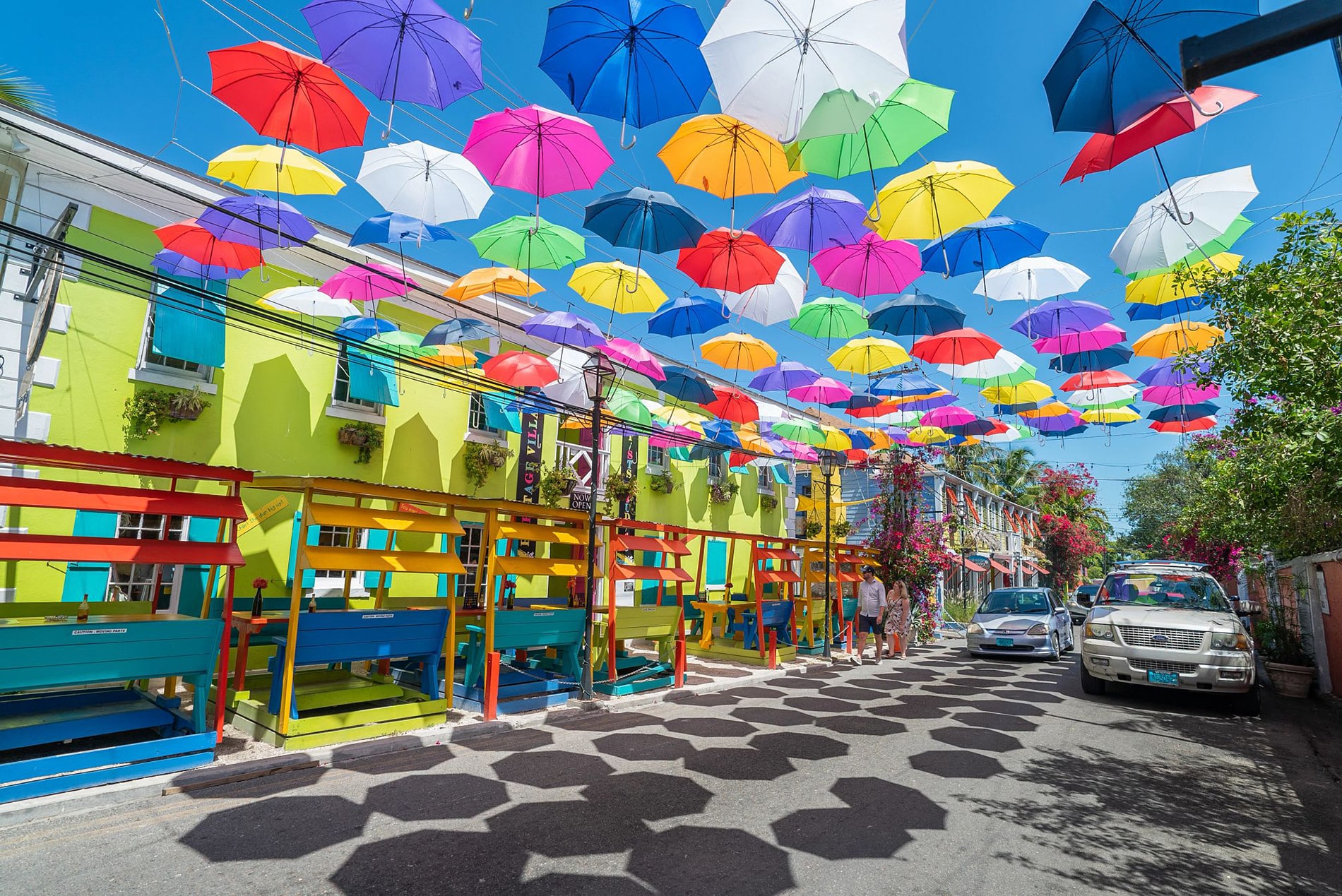 A canopy of vivid umbrellas floats above a spirited streetscape in downtown Nassau.