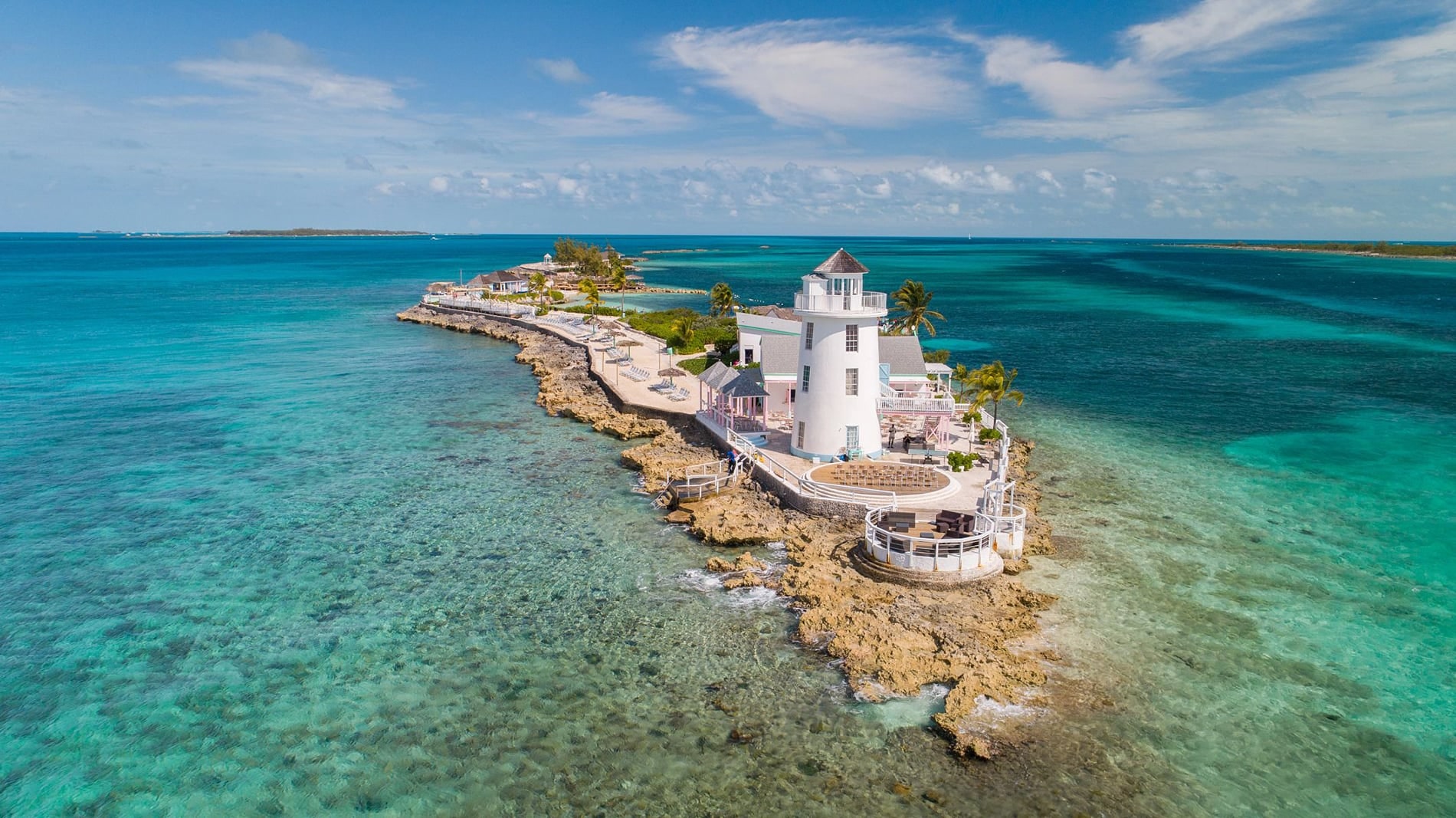 A breathtaking bird's-eye perspective of the legendary lighthouse at Pearl Island, nestled amidst the glistening turquoise expanse of The Bahamas.