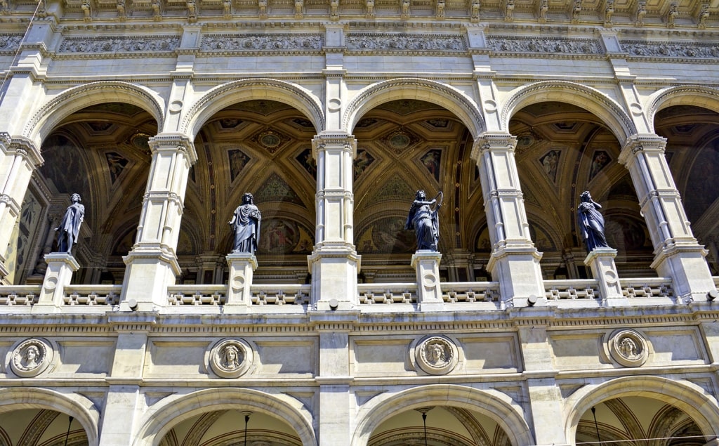 Classic statues gracefully embellish the arched loggia of the magnificent Vienna State Opera.