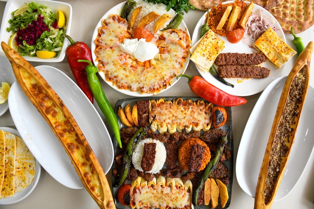 A decadent spread of traditional gastronomy showcases warm, sesame-crusted pide alongside succulent grilled meats and a vibrant array of flavorful meze.