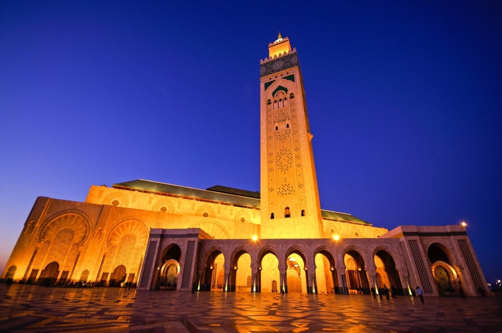 As twilight descends, the magnificent Hassan II Mosque in Casablanca is bathed in a brilliant glow.