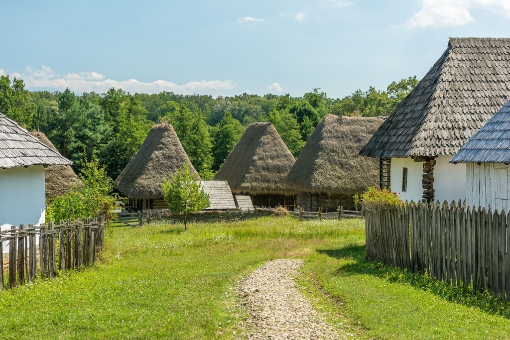 Traditional thatched-roof houses at the Dimitrie Gusti National Village Museum in Bucharest, Romania.