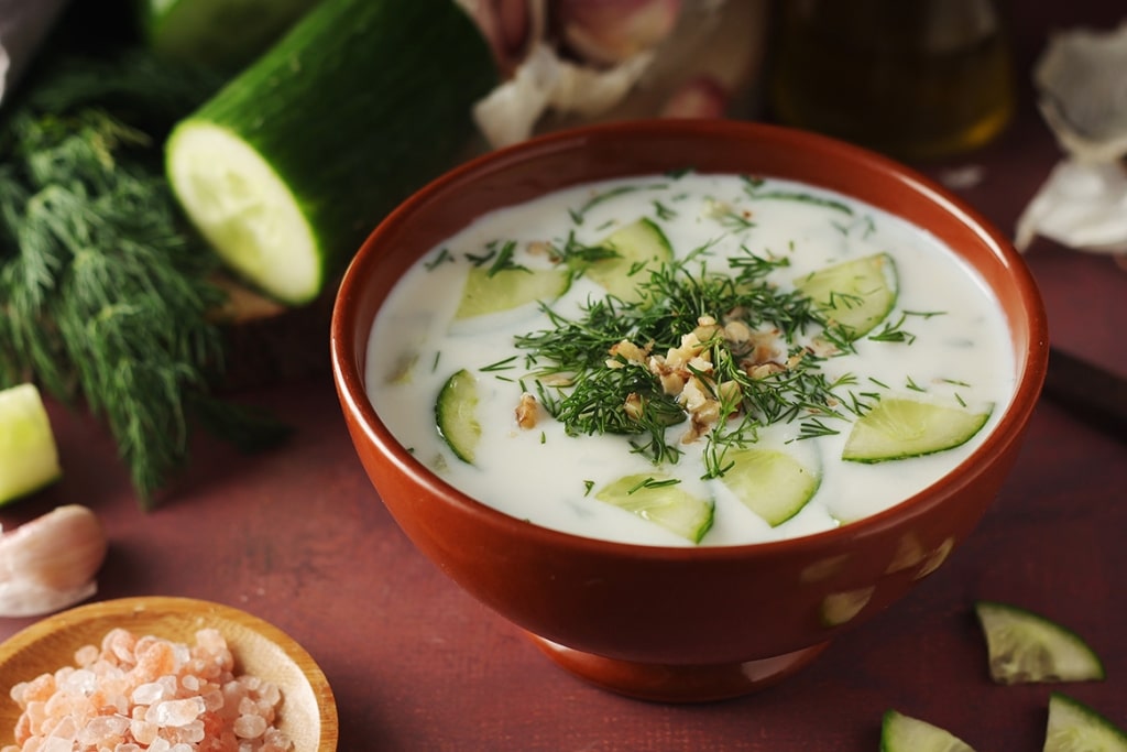Traditional bulgarian cold summer soup tarator with yogurt, dill, cucumber and walnuts.