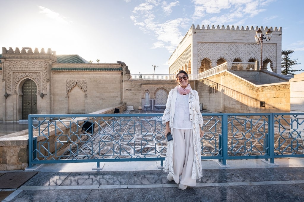 A tourist stands before the architectural splendor of Rabat’s Mausoleum of Mohammed V.