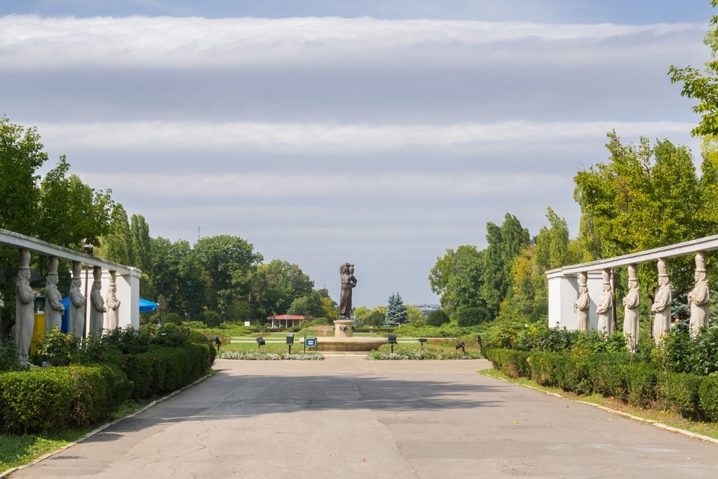 Graceful classical statues welcome travelers into the lush tranquility of Bucharest’s Herăstrău Park.