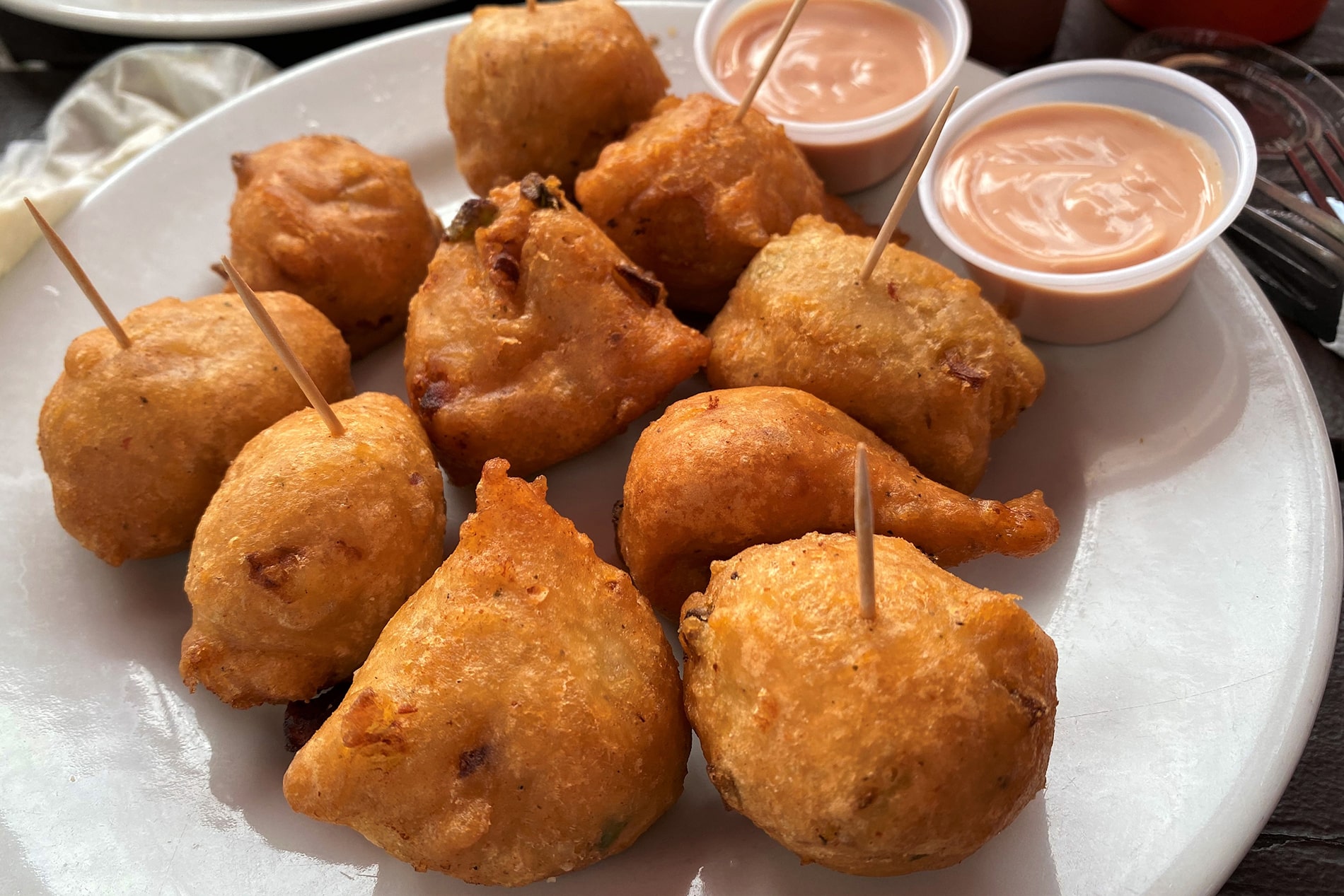 Golden-brown conch fritters served fresh with tangy dipping sauce offer a delicious, tactile taste of local island street food during Nassau port stop