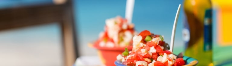 Two bowls of Bahamian conch salad and bottle of beer