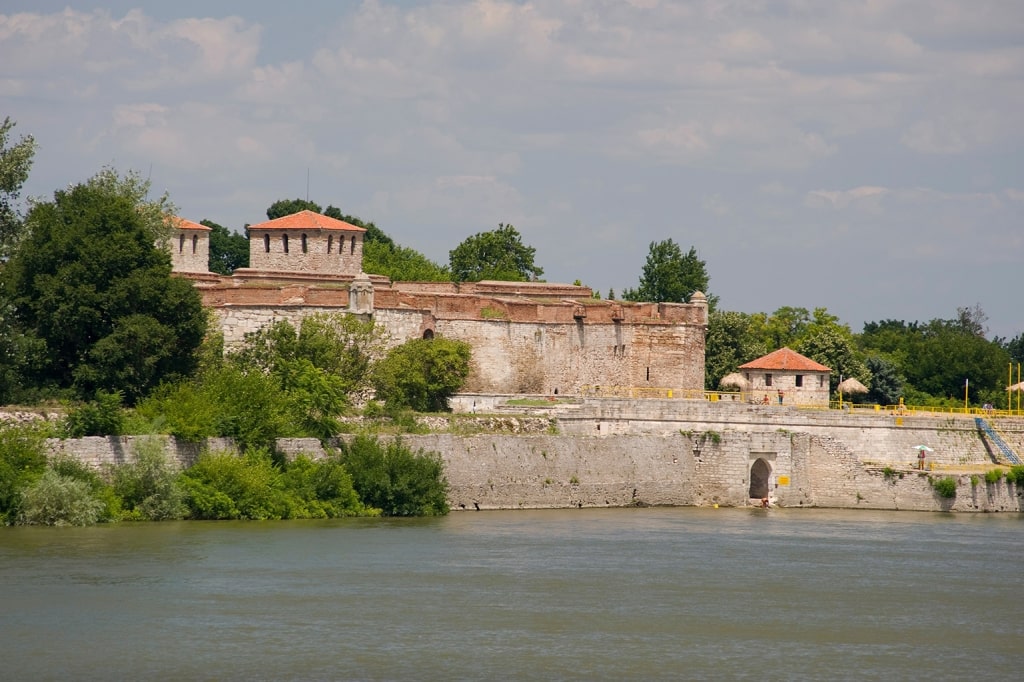 Strong stone structures of the Baba Vida Fortress tower over the bank, stretching along the scenic Danube.