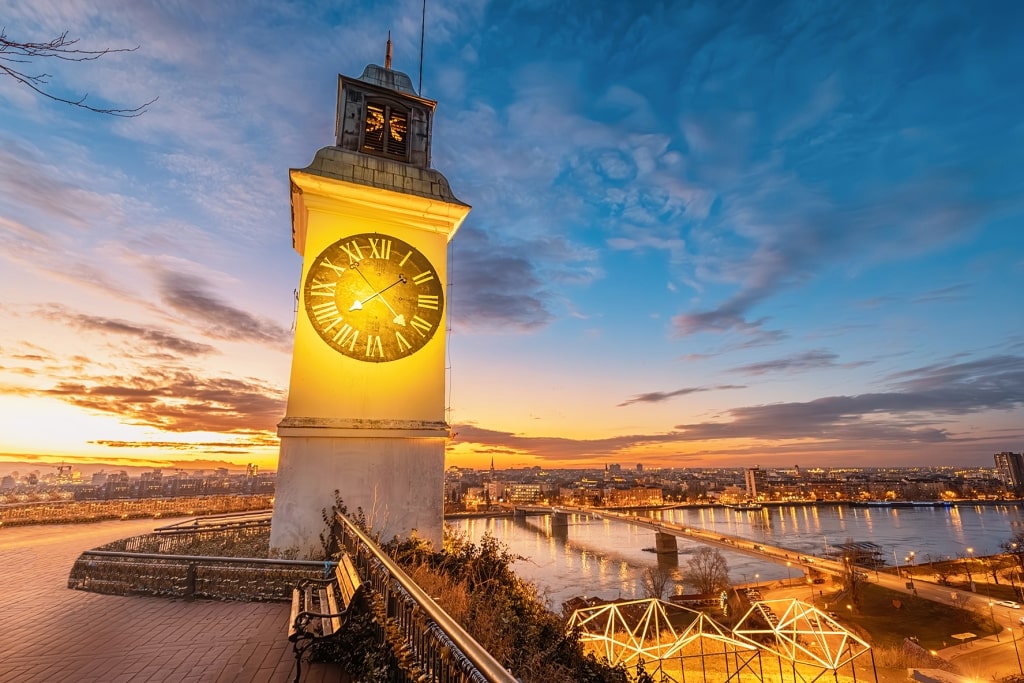Sunset illuminates the iconic Petrovaradin Fortress clock tower in Novi Sad.