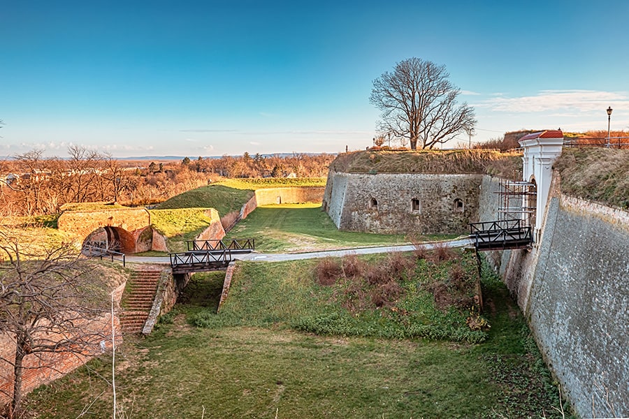 Gleaming stone ramparts and verdant moats reveal the historic allure of Petrovaradin Fortress in Novi Sad.