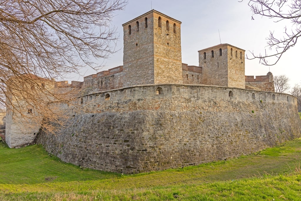 Baba Vida Fortress's medieval stone towers rise above lush Bulgarian hills.