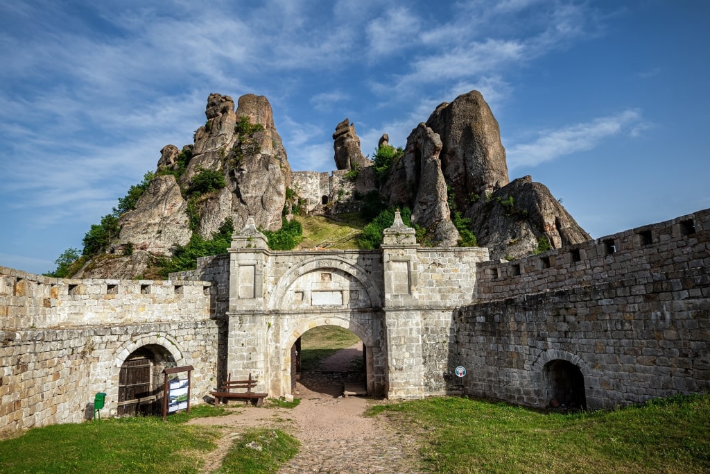 The medieval stone gates at Belogradchik are dwarfed by the dramatic, monolithic sandstone formations that tower above them.