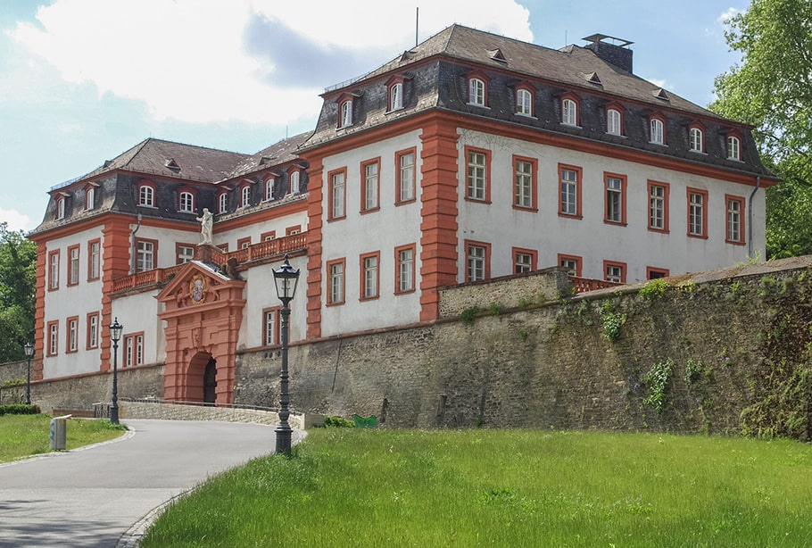The Baroque entrance of the Mainz Citadel stands above historic stone walls, offering a peaceful glimpse into centuries of military history overlooking the Rhine.