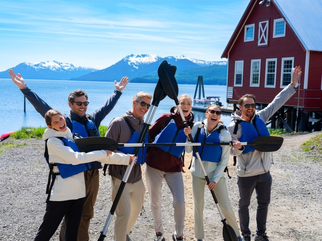 Happy travelers enjoy their shore excursion with icy Alaskan peaks in the background and total peace of mind thanks to cruise insurance protection from Celebrity Cruises.