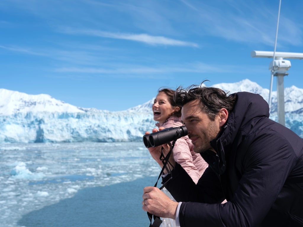Passengers look through binoculars to view the massive ice wall of the Hubbard Glacier in Alaska from the deck of a Celebrity Cruises’ ship.