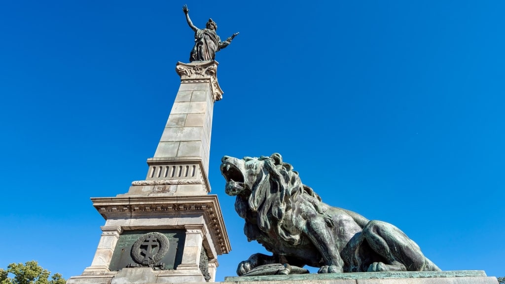 A bronze lion guards the towering Monument of Liberty in Ruse.