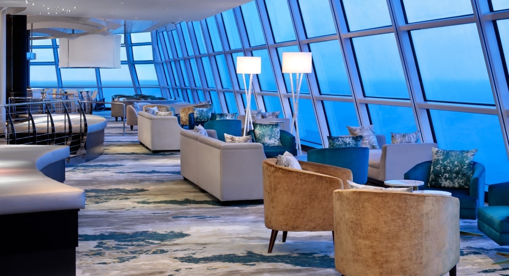 Floor-to-ceiling windows frame sweeping ocean vistas from stylish, comfortable seating inside the Sky Observation Lounge.