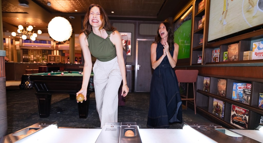 Friends share a joyful moment over games in the warm, nostalgic setting of The Parlor.