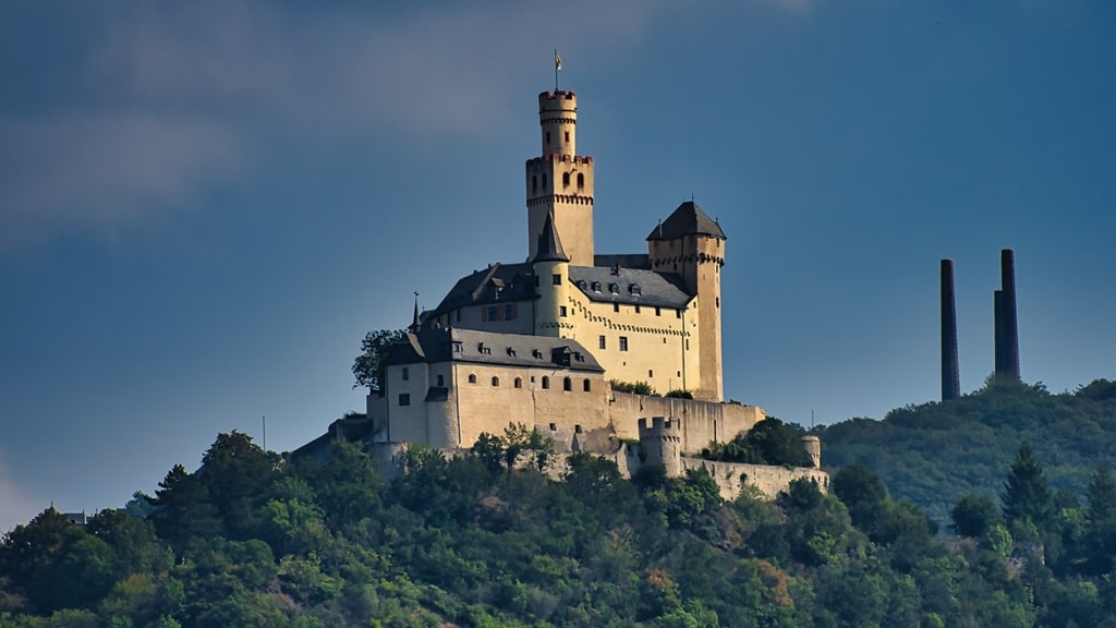 A Beautiful view of Marksburg castle on the top of a forested mountain.