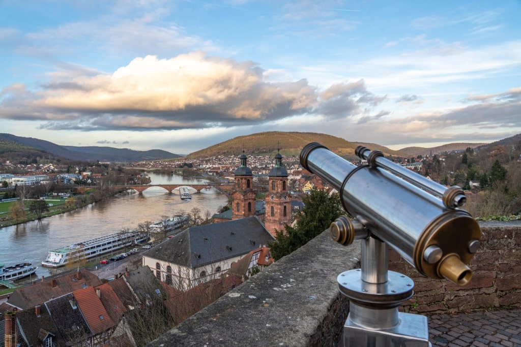 A panoramic view from Miltenberg Castle overlooking the Main River, the twin towers of St. Jakobus Church, and the surrounding valley.