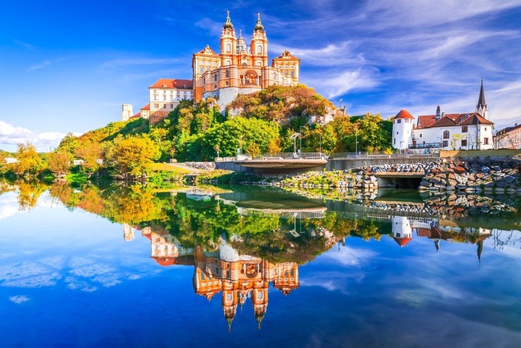 Melk Abbey, Austria. The abbey is reflected in the water of the Danube River on a sunny autumn day in the scenic Wachau Valley.