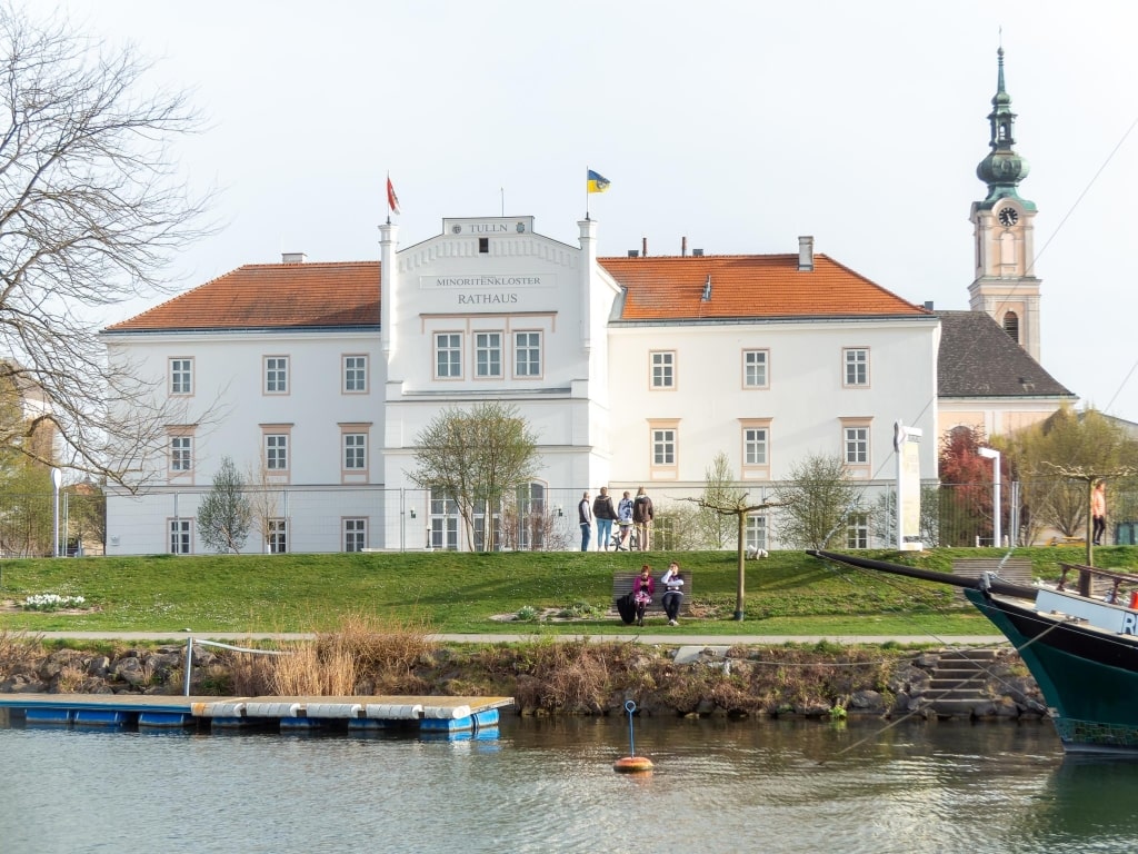 The Minoritenkloster (Rathaus) and church tower viewed from the Danube waterfront promenade.