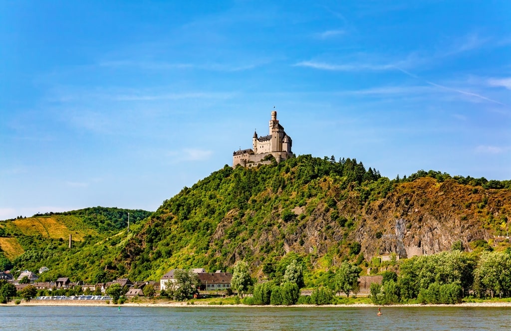 The medieval Marksburg Castle sits atop a hilltop overlooking the Rhine River, standing as the only un-destroyed hill castle in the Middle Rhine region.