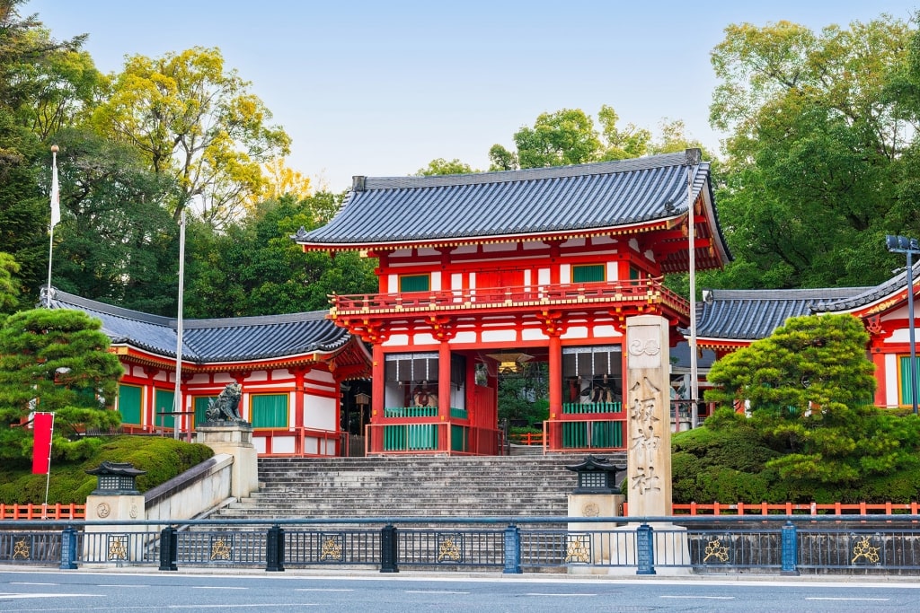 The iconic Nishi-ro-mon (West Gate) entrance and stone pillar of Yasaka Shrine at the eastern end of Shijo Avenue in the Gion district.