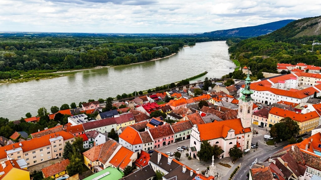 An aerial view showcases Hainburg's red rooftops along the Danube River.
