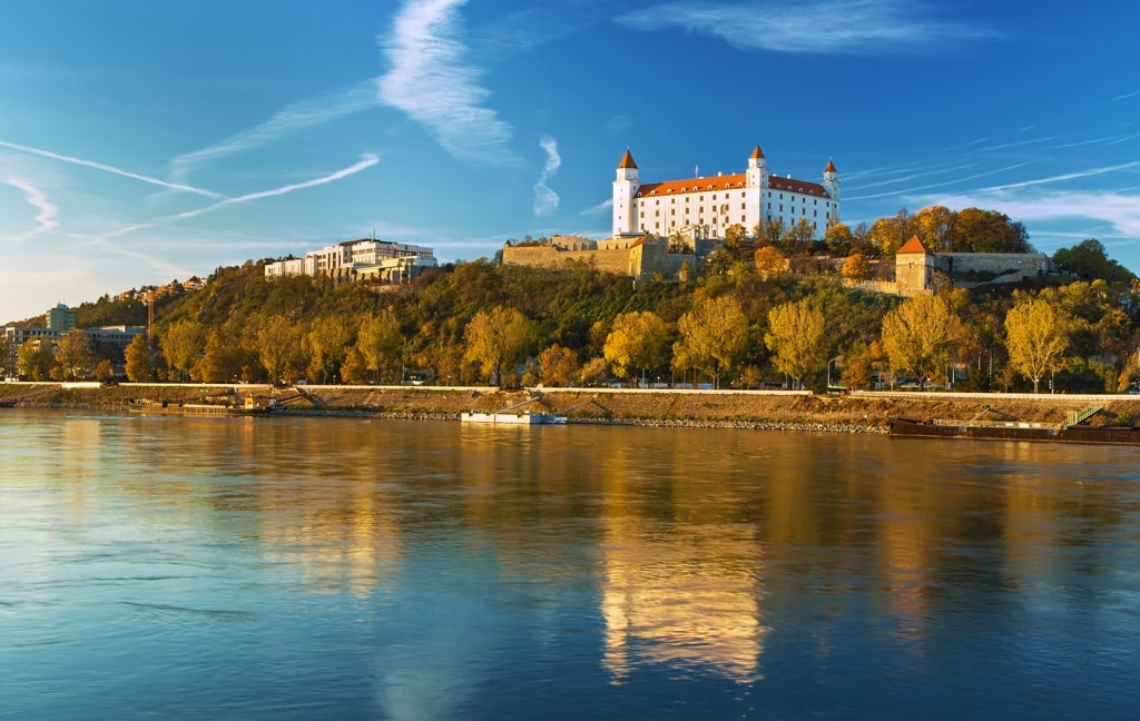View of Bratislava Castle, Parliament, and Danube River at sunset in autumn in Bratislava, Slovakia